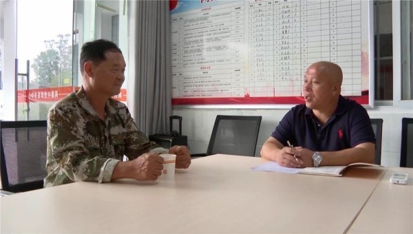 杜雅军（右）在与种植大户对接水稻管护相关事宜。刘奕麟摄