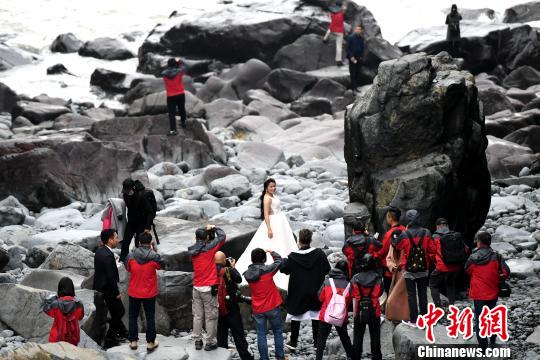 海边的石头景色吸引了新人前来拍婚纱照。　王东明 摄