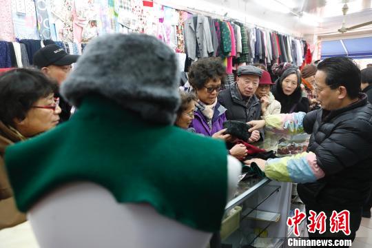 店内五六十岁的阿姨爷叔结伴而来买“假领头”，排队时不可避免的。　殷立勤　摄