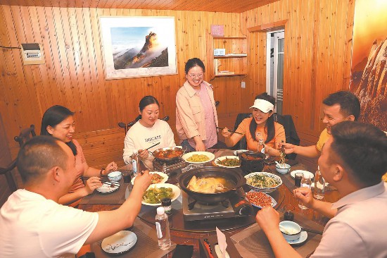 5月16日，葛翔宇抓住上菜时机，听取游客对卧龙山庄民宿的意见和建议。