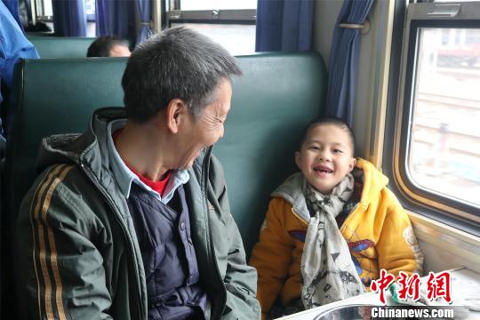一对爷孙在返乡列车上高兴大笑。　　吴鹏泉 摄